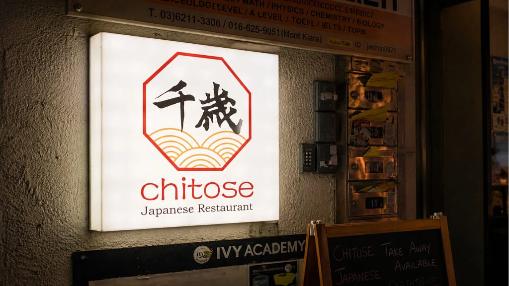 Chitose Japanese Restaurant brand identity signage featuring Japanese calligraphy logo, octagonal crest frame, and golden wave motif — Japanese restaurant branding and creative direction by Serah Siew